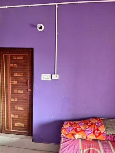 a purple room with a door and a purple wall at Sri Chaitanya Saraswat Math in Krishnanagar