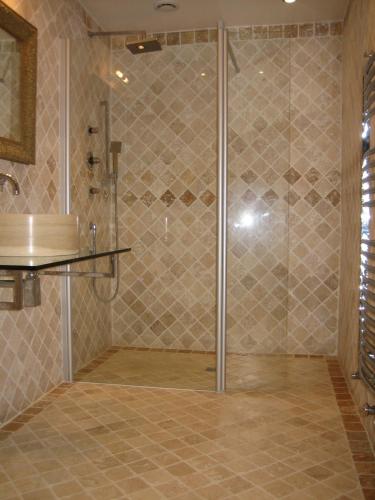 une douche avec une porte vitrée dans une salle de bain dans l'établissement Villa - La chambre des Dames, à Vallères