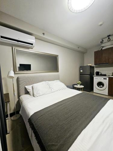 a bedroom with a large bed and a kitchen at JL Condotel - Near Airport - Oceanview in Lapu Lapu City