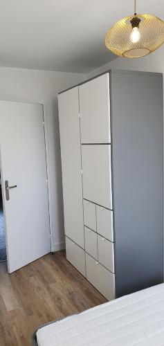 Cette chambre comprend une armoire blanche et un plafond. dans l'établissement Cyclades Appartement dans Résidence Piscine Tennis Boulodrome, au Lavandou