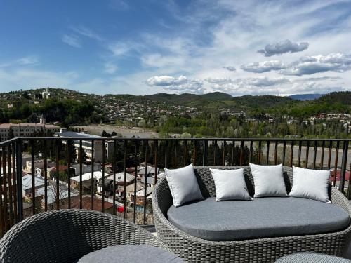 a wicker couch sitting on top of a balcony at Rioni & Bagrati Panorama in Kutaisi