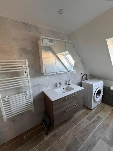 une salle de bain avec un lavabo et une machine à laver dans l'établissement Le 9 de fer, à Colmar