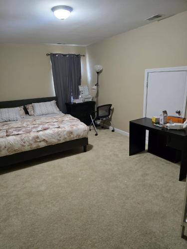 Un dormitorio con una cama y un escritorio y un escritorio. en Modern Marvel Home, en Hope Mills