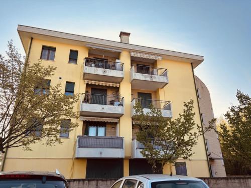 a yellow building with balconies and cars parked in front at Venice Home perfect for Venice airport free parking in San Liberale