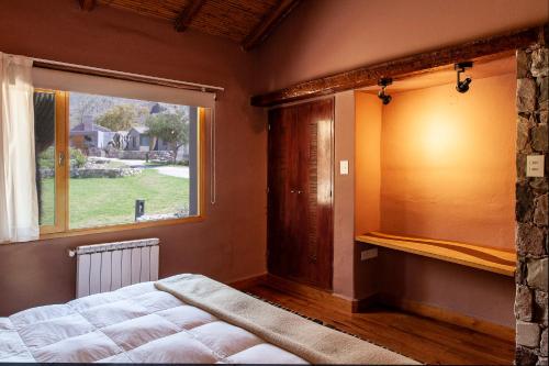a bedroom with a bed and a large window at La Comarca Hotel in Purmamarca
