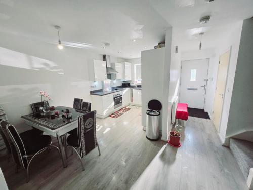 a white kitchen with a table and chairs in a room at Charming Room, shared house in Oldham
