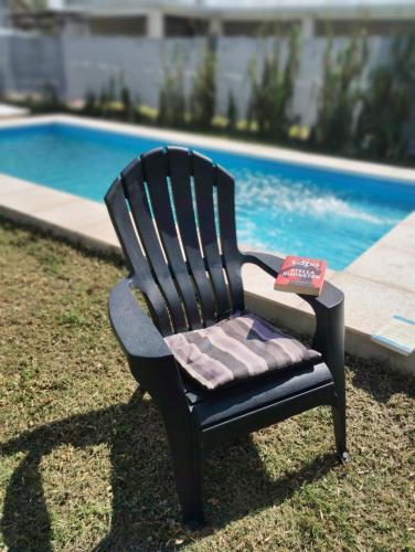 a black chair with a book on it next to a pool at Funes Inn in Funes