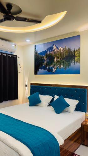 a bedroom with a large bed with blue and white pillows at Hotel RJ in Patna