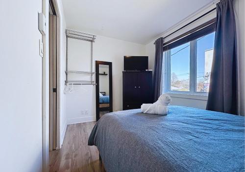 a bedroom with a bed with a teddy bear sitting on it at Élégant et cosy - 2 chambres bien équipé et parking gratuit in Montréal