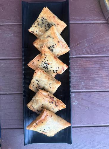 a black plate with eight pieces of crackers at hotel in manali by Aura in Vashisht