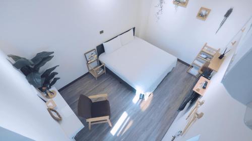 an overhead view of a bedroom with a bed and a chair at 咻咻宿 Xiuxiu 電梯宅 in Taitung City