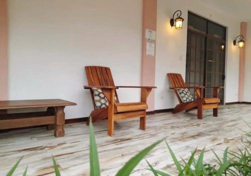 three wooden chairs and a table in a room at Entire Home Near Beach, Quiet Area, Pool in Manzanillo