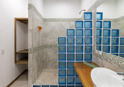 a bathroom with blue tiled walls and a sink at Entire Home Near Beach, Quiet Area, Pool in Manzanillo