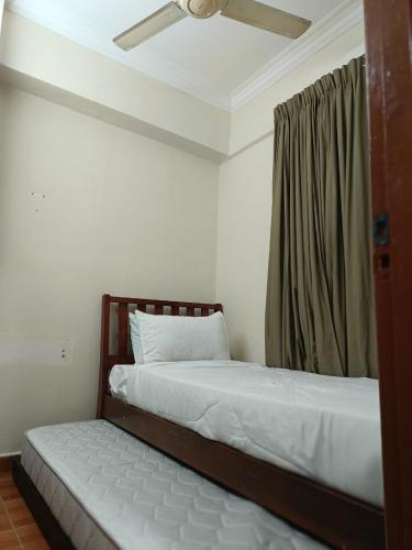 ポートディクソンにあるERICCA 3 Bedroom Seaview Suite, Glory Beach Resort, PDのベッド2台と天井ファン付きの寝室