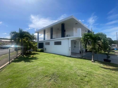 a white house with palm trees in front of it at Casa Ramos in Aguadilla