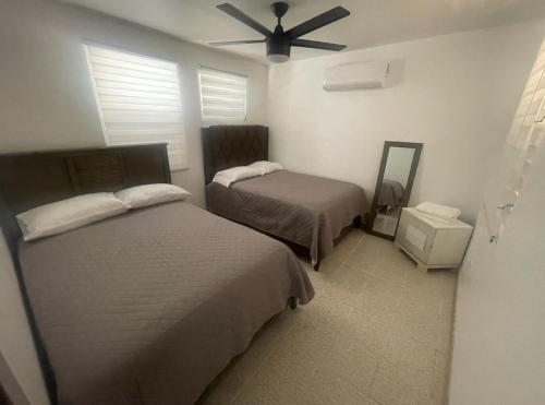 a bedroom with two beds and a ceiling fan at Casa Ramos in Aguadilla