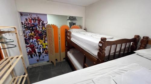 two bunk beds in a room with a poster on the wall at COACHHOSTEL7 in Sao Paulo