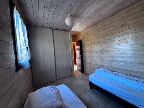 a wooden room with a bed and a window at Villa Les Vignes in Salavas