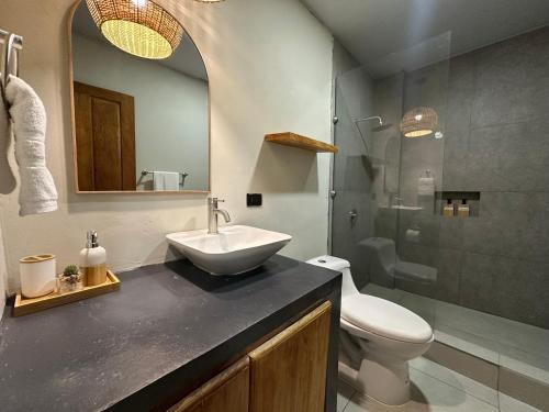 a bathroom with a sink and a toilet and a mirror at Litos Hotel in La Libertad