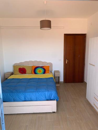 a bedroom with a blue bed and a brown door at Orizzonte Blu Holiday Home in Scalea