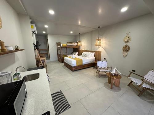 a bedroom with a bed and a kitchen with a sink at Litos Hotel in La Libertad