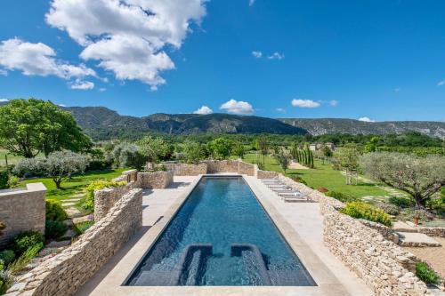 a pool in a villa with mountains in the background at La Bastide in Oppède