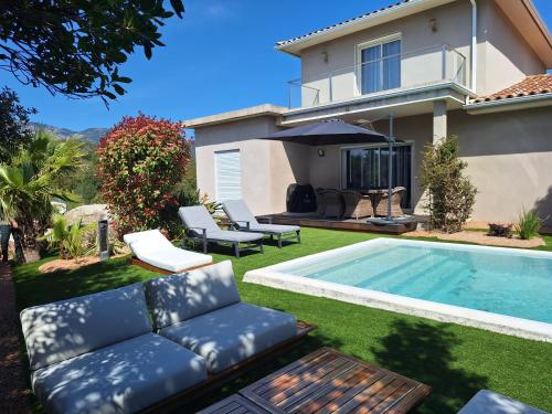 une cour arrière avec une piscine et une maison dans l'établissement Villa 130 m2 dans domaine privé aux pierres roses, à Porto-Vecchio