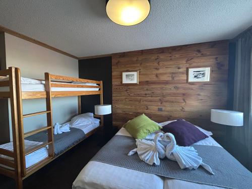 a bedroom with two bunk beds and a ladder at Hillary Hotel in Les Menuires