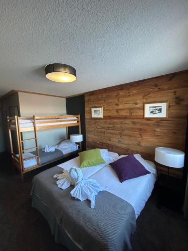 a bedroom with two beds and a bunk bed at Hillary Hotel in Les Menuires