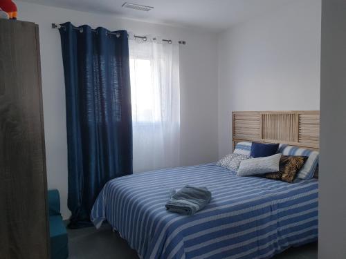 une chambre avec un lit à rayures bleues et blanches dans l'établissement Villa 130 m2 dans domaine privé aux pierres roses, à Porto-Vecchio