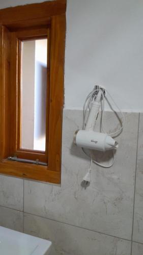 a hair dryer on the wall of a bathroom at ROCA AZUL in El Bolsón