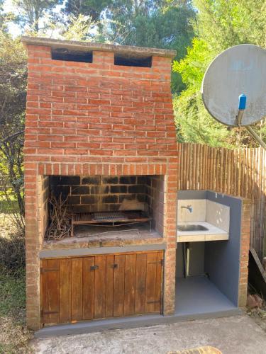 a brick oven with a sink and a mirror at Entre Verdes in Valeria del Mar