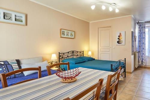 - un salon avec un lit et une table dans l'établissement Studio PETIT JUNO, à Courseulles-sur-Mer