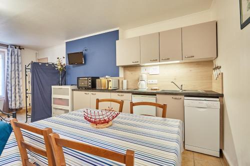 une cuisine avec une table et des chaises et une cuisine avec un comptoir dans l'établissement Studio PETIT JUNO, à Courseulles-sur-Mer