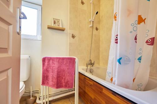 La salle de bains est pourvue d'une douche, de toilettes et d'une baignoire. dans l'établissement Studio PETIT JUNO, à Courseulles-sur-Mer