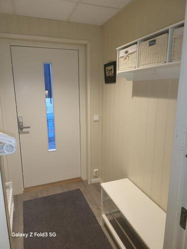a room with a door with a bench and a window at Koselig Leilighet i Narvik sentrum 5 Soveplasser Gratis parkering og Gratis internet in Narvik