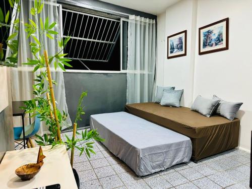 twee bedden in een kamer met een raam en planten bij Vista mar, piscina, na praia do futuro, com Ar condicionado e Wi-Fi in Fortaleza