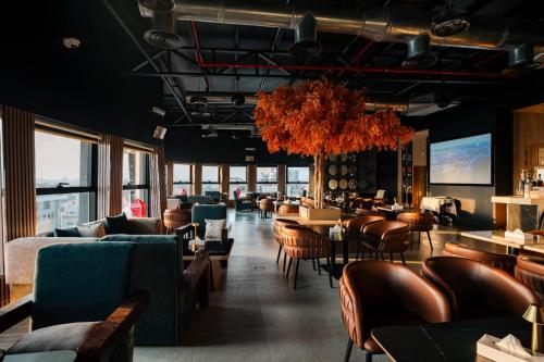 a restaurant with couches and tables and chairs at Aluya Hotel in Jeddah