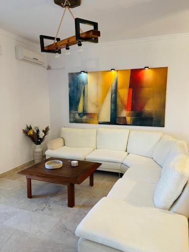 a living room with a white couch and a coffee table at Blue Pearl Beach House in Sozopoli