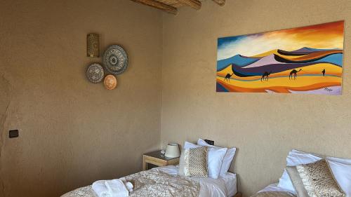 a bedroom with a bed and a painting on the wall at Les Jardins de la Santé in Tamazouzte