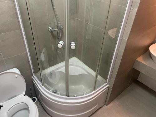 a shower stall with a toilet in a bathroom at Apartament Central In Luceafărul Oradea Free Parking in Oradea