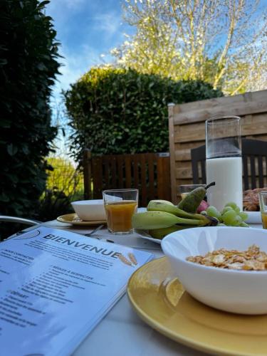 a table with a bowl of food and a glass of milk at La Maisonnette - 2 chambres, parking, jardinet & calme in Tournai