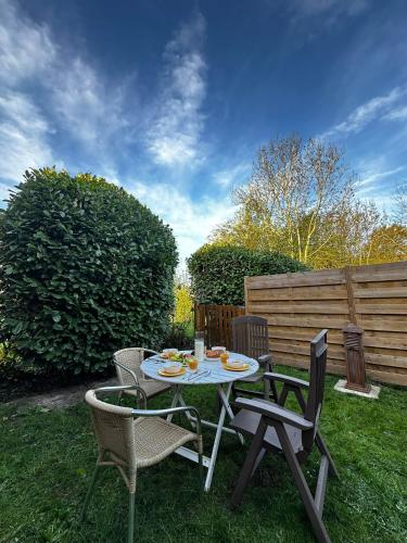 a table and chairs sitting on the grass at La Maisonnette - 2 chambres, parking, jardinet & calme in Tournai