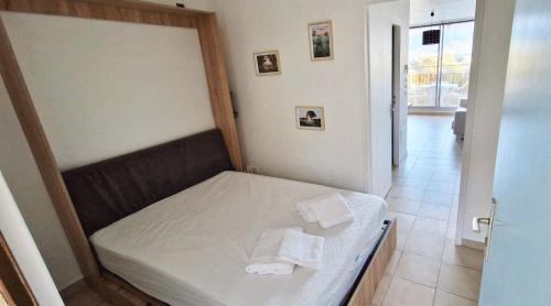 - un lit dans une chambre avec 2 serviettes dans l'établissement Résidence les Mimosas, à Calvi