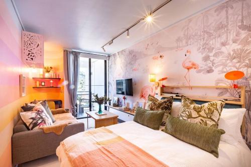 a living room with a bed and a couch at Elegant Studio by the Sea in Cape Town