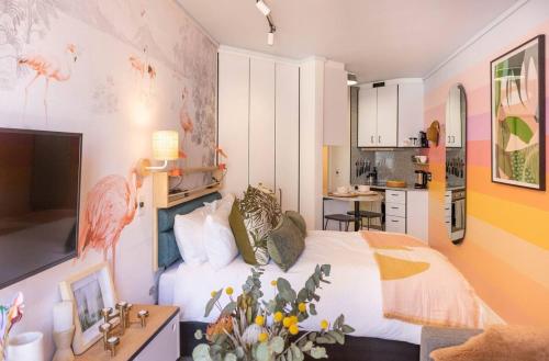 a bedroom with a bed and a kitchen at Elegant Studio by the Sea in Cape Town