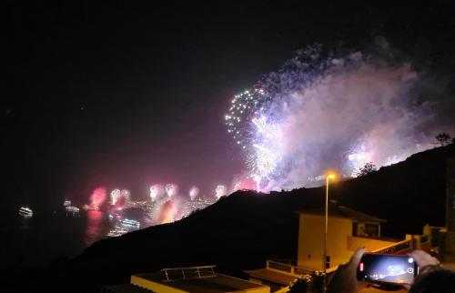 a person taking a picture of a fireworks show at night at Villa-Kasia Ocean View Studios in Caniço
