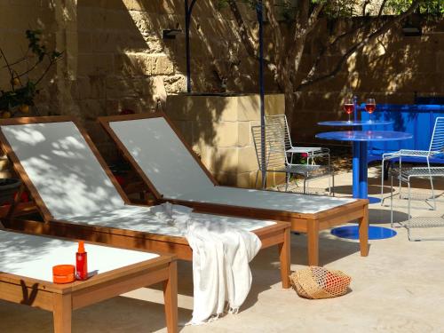 a pair of tables and chairs in a patio at Alba in Sliema