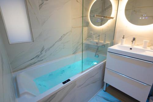 a bathroom with a tub and a sink and a shower at Ô Repos des artistes - Balcon & Spa in Toulon