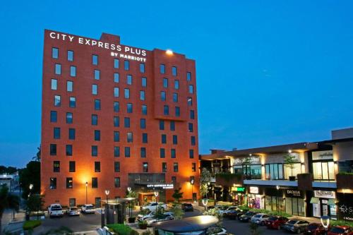 a tall red building with a city express plus sign on it at City Express Plus by Marriott Tampico in Tampico